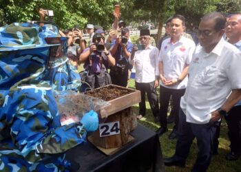 MOHAMED Khaled Nordin (kanan) mendengar taklimat berhubung pengendalian lebah kelulut ketika menghadiri Majlis Pelancaran Program Ekonomi MADANI Angkatan Tentera Malaysia (PEM ATM) di Batalion Kelima Rejimen Askar Melayu Diraja (5 RAMD), Kem Batu 3, Kluang.