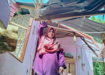 FATIMAH Harun menunjukkan bumbung rumahnya yang ranap dihempap pokok asam gelugur akibat ribut di Kampung Banggol Kekabu Rantau Panjang, Kelantan. - UTUSAN/ROHANA ISMAIL