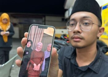 MUHAMMAD Faris Zulkifly menunjukkan gambar Allahyarham Nurfisya (tengah) ketika ditemui di Unit Forensik HRPZ II, Kota Bharu, Kelantan.