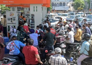 GAMBAR fail sejumlah penunggang motosikal mengisi petrol di sebuah stesen minyak di  Amritsar. - AFP