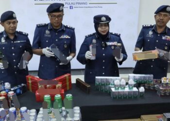 RAMIZAH Bee Salleh Ghany (dua dari kanan) menunjukkan sebahagian daripada rokok dan minuman keras yang dirampas dalam dua serbuan berasingan ketika sidang akhbar di Bagan Jermal, Butterworth, Pulau Pinang hari ini.-UTUSAN/DANIAL SAAD