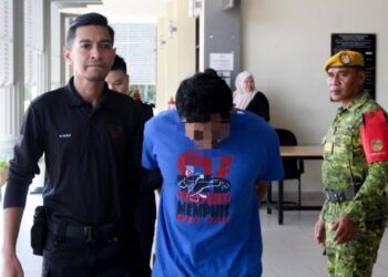 TERTUDUH semasa diiringi polis untuk prosiding perbicaraan di Mahkamah Sesyen, Pasir Mas, Kelantan hari ini. - UTUSAN/KAMARUL BISMI KAMARUZAMAN