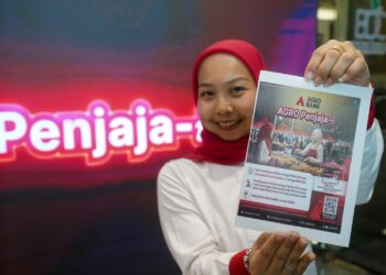 Eksekutif Kanan Perhubungan Awam Agrobank, Fatin Shaheera Mohd Rosli menunjukkan skim pembiayaan mikro AGRO Penjaja-i. -UTUSAN/FAISOL MUSTAFA