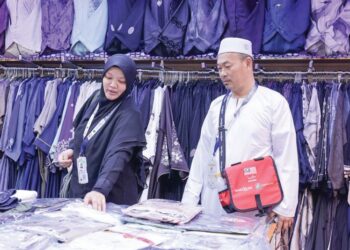 MUHAMMAD Zamarul Hafiz Ho Abdullah bersama isterinya, Kamariah Othman meninjau barangan di pasar raya berhampiran Masjidil Haram, Mekah.