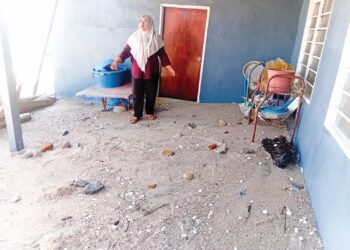 PENDUDUK menunjukkan pasir yang memenuhi  rumah mereka akibat kejadian air pasang besar di Kampung Huma, Tanjung Dawai di Sungai Petani.