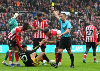 Pengadil perlawanan, Stuart Attwell  (kanan) melayangkan kad kuning kepada penyerang Manchester United, Matheus Cunha dalam aksi Liga Perdana Inggeris menentang Sunderland di Stadium of Light, Sunderland, hari ini. - AFP