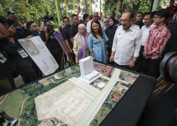 ANWAR Ibrahim melihat pelan pangsapuri pada Majlis Pecah Tanah Perumahan Kekal bagi Penduduk Rumah Panjang di Tapak Rumah Panjang Bukit Kiara, Kuala Lumpur hari ini.-UTUSAN/MUHAMAD IQBAL ROSLI