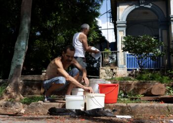 PENDUDUK kawasan kejiranan Vedado mengisi air ke dalam baldi untuk dibawa pulang ke rumah mereka yang terputus bekalan di Havana. - AFP