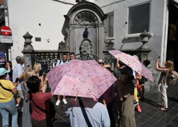 PELANCONG menggunakan payung  akibat cuaca panas di Brussels, Belgium. - AFP