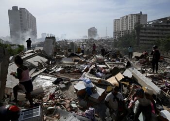 PENDUDUK tempatan berjalan di celah runtuhan bangunan susulan dua gempa bumi yang melanda Caraballeda kelmarin. - AFP