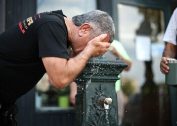 SEORANG lelaki menyejukkan badan di sebuah pancutan air minuman awam di Paris, kelmarin. - AFP