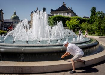 SEORANG pelancong menyejukkan diri di Copenhagen. - AFP