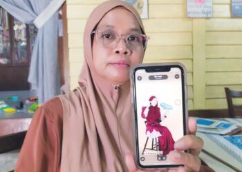 CHE Nor Aida Suhana Mat menunjukkan gambar kenangan Allahyarham Anis Soffiya Md. Zaidi, ketika ditemui di Kampung Rahmat, Setiu, Terengganu.