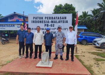 MUSTAPHA (empat,kiri) berada di batu sempadan antara Malaysia-Indonesia di Pulau Sebatik sempena lawatan kerja berkaitan pembinaan pos kawalan sempadan.  - UTUSAN/NASRAWATI SYARIFUDDIN