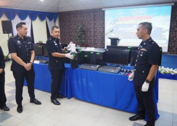 HALIM Abas menunjukkan sebahagian barangan rampasan hasil serbuan ke atas sebuah sindiket penipuan pelaburan saham dalam talian tidak wujud di IPK Melaka hari ini.