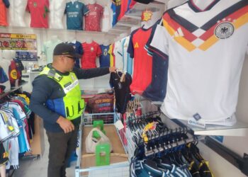 ANGGOTA KPDN negeri melakukan pemeriksaan di salah sebuah premis kedai semasa operasi di sekitar Padang Besar, Perlis, Selasa lalu. -UTUSAN