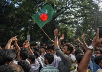 RATUSAN pelajar mengibarkan bendera kebangsaan Bangladesh ketika mengadakan protes menuntut peletakan jawatan menteri pendidikan. - AFP
