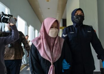 SOFIA Rini Buyong yang didakwa atas pertuduhan mengeluarkan kenyataan berunsur fitnah terhadap ahli perniagaan, Datuk Seri Farhash ketika diiringi pegawai polis di Mahkamah Majistret Kuala Lumpur, di sini hari ini. - UTUSAN/SYAKIR RADIN