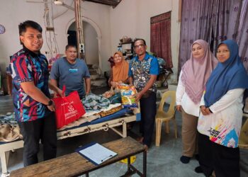 ANWAR Abdullah (tiga dari kanan) menyampaikan bantuan kepada keluarga Ramli Ismail sempena program Ziarah Kasih di kediaman mereka di Felda Jengka 5 di Maran, Pahang. - FOTO/SALEHUDIN MAT RASAD