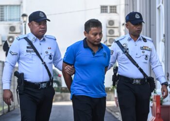 MOHD. Norazlan Mohd. Tamyiz yang didakwa merempuh tiga sekeluarga ketika memandu di bawah pengaruh dadah diiringi anggota polis trafik ke Mahkamah Kajang, di sini hari ini. - UTUSAN/SYAKIR RADIN
