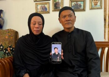 ZULFAH Fadliani (kiri) dan suaminya, Ahmad Ros Abidin menunjukkan gambar Ahmad Shah di kediaman mereka di Bandar Tasik Puteri, Rawang, Gombak, baru-baru ini.