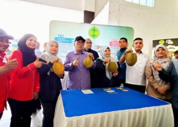 MOHD. Zolkafly Harun (tengah) menunjukkan buah durian pada Majlis Jelajah Sejahtera Agro @ DUN Lintang di Arena Sungai Siput hari ini.