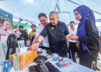 AHMAD Zahid Hamidi melihat produk Lateks yang dipamerkan sempena Program Salam Agrikomoditi Madani di Dataran Melang, Kuala Pilah, Negeri Sembilan, semalam.