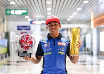 Hakim Danish bersama trofi yang dimenanginya pada Kejuaraan Dunia Moto3 sewaktu tiba dari Jerman di Lapangan Terbang Antarabangsa Kuala Lumpur (KLIA), Sepang, semalam. - Ihsan SIC Racing
