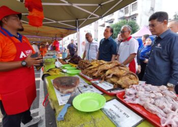 TENGKU Ahmad Badli Shah Raja Hussin (dua dari kanan) dan Chan Ming Kai (tiga dari kanan) bertemu peniaga semasa Program Lawatan Pasar Tani Ampangan di Seremban, Negeri Sembilan semalam. - UTUSAN/MOHD. SHAHJEHAN MAAMIN.
