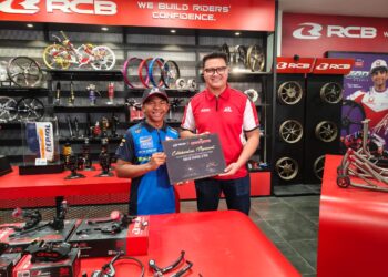Hakim Danish (kiri) bersama Pengurus Jenama RCB, Amir Azizi Rahman sewaktu pelumba Moto3 itu hadir ke pejabat RCB di Puchong, Selangor, semalam. - UTUSAN/AIZAWATI AHMAD
