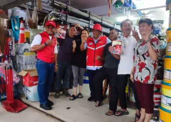 AMINUDDIN Harun (tengah) dan Amirudin (kiri) bergambar bersama orang ramai ketika berkempen di pekan Linggi, Port Dickson pagi ini.