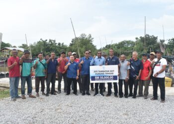 ABDUL Salim Tajudin (tujuh dari kanan) membuat gimik penyerahan cek cura yang diperuntukkan bagi membiayai projek pembinaan jeti tambatan bot di Kampung Kurung Tengar, Kuala Perlis, Perlis hari ini. -UTUSAN/ASYRAF MUHAMMAD