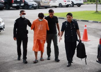 TERTUDUH semasa dibawa oleh polis untuk menghadiri prosiding perbicaraan di Mahkamah Pasir Mas, Kelantan. - UTUSAN/KAMARUL BISMI KAMARUZAMAN