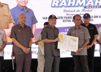Hajiji Noor (tiga kanan) menyerahkan geran pewartaan kampung kepada wakil lima kampung di Kalabakan.