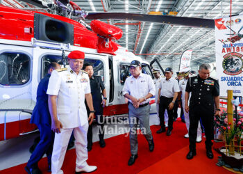 SAIFUDDIN Nasution Ismail diiringi Mohd. Rosli Abdullah (kiri), melihat helikopter AW189 pada Majlis Penerimaan Helikopter AW189 Agensi Penguatkuasa Maritim Malaysia di Stesen Udara Maritim Subang, semalam. – UTUSAN/SHIDDIEQIIN ZON