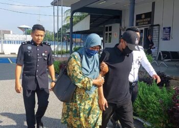TERTUDUH (dua dari kanan) ditemani ahli keluarga (dua dari kiri) ketika keluar dari kamar mahkamah sambil diiringi anggota polis di Mahkamah Majistret, Pekan, Pahang.