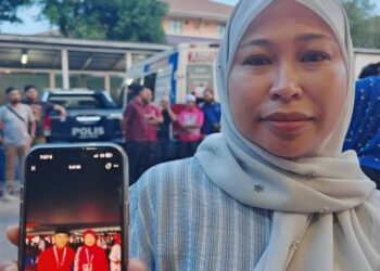 NORHASNIRAWANI Hashim menunjukkan gambar terakhir beliau bersama Allahyarham Mohd. Radzi Rahimi yang dirakam ketika Mesyuarat Agung UMNO Bahagian Maran pada 26 Julai lalu, yang kini menjadi kenangan terakhir bersama sahabat seperjuangannya.