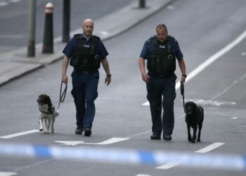 DUA anggota polis Britain bersama dua ekor anjing. - AFP