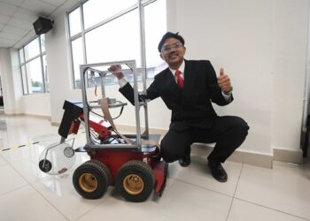 AHMAD Faris Ahmad Fuad bersama robot autonomi bagi mengatasi isu kutipan buah lerai sawit yang diciptanya.