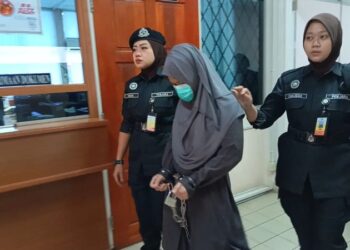 NURIMA Juli dibawa keluar dari Mahkamah Tinggi Tawau hari ini selepas selesai memberi keterangan sebagai saksi bagi pihak plaintif. - UTUSAN/NASRAWATI SYARIFUDDIN