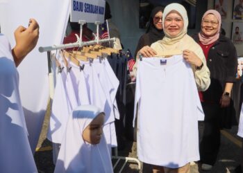 FADHLINA Sidek (dua dari kanan) melihat contoh baju sekolah yang boleh dibeli secara ansuran daripada NADI pada Program Madani Kita Bersama Komuniti Nibong Tebal di Simpang Ampat, Nibong Tebal, Pulau Pinang hari ini.-UTUSAN/DANIAL SAAD