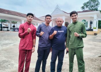 ALIFF Rakib (kanan) bergambar dihadapan rumahnya di Taman Sri Rantau Rantau Panjang Kelantan.-FOTO ROHANA ISMAIL