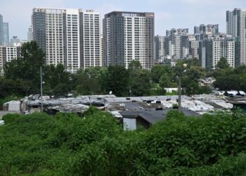 Pemandangan menunjukkan perkampungan setinggan Guryong (bahagian bawah gambar) di pinggir daerah Gangnam, Seoul. - AFP