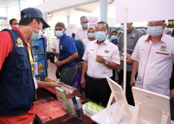 NOOR Azmi Ghazali (dua dari kanan) melawat salah sebuah gerai pameran yang mengambil bahagian dalam program Komuniti Sihat Pembina Negara di Sabak Bernam, Selangor, semalam.