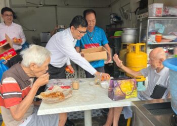 AKMAL NASRULLAH MOHD. NASIR (tengah) mengagihkan limau sempena sambutan Tahun Baharu Cina di Pasar Pagi Taman Pelangi, Johor Bahru.