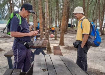 ISHAK KAMIS (kiri) dan saudara mara yang lain akan terus mencari Muhamad Akmal di Pulau Mawar meskipun SAR ditamatkan.