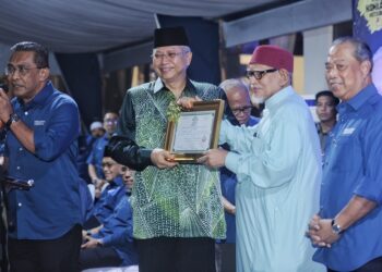 ABDUL Hadi Awang menyerahkan sijil keahlian Pas kepada Annuar sambil diperhatikan Muhyiddin pada Ceramah Perdana Gelombang Kebangkitan Rakyat Negeri Sembilan di Senawang, Seremban malam ini.-UTUSAN/MOHD. SHAHJEHAN MAAMIN.