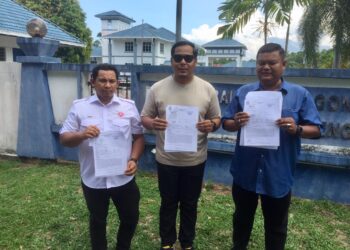 MOHD. Hafiz Aziz (tengah) menunjukkan laporan polis berhubung kenyataan fitnah dibuat di akaun Facebook palsu menggunakan nama Ahmad Razif Abdul Rahman di Balai Polis Gong Badak, Kuala Nerus, Terengganu hari ini.