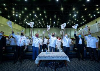 Tan Sri Abang Johari Tun Openg (tengah) mengibarkan bendera GPS ketika meraikan kemenangan parti itu dalam Pilihan Raya Negeri Sarawak ke-12 di Pusat Konvesyen Borneo Kuching (BCCK) kelmarin. - UTUSAN/ MUHAMAD IQBAL ROSLI