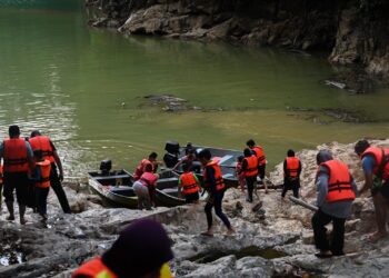 SEKUMPULAN pelancong   meninjau air di Air Terjun Sungai Lasir di Tasik Kenyir yang keruh sebelum memulakan aktiviti di kawasan tersebut. – UTUSAN/PUQTRA HAIRRY ROSLI